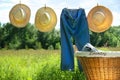 Blue jeans and straw hats on clothesline