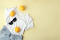 Blue jeans, white shirt, sunglasses and lemons on yellow background. Women`s stylish spring summer outfit. Trendy clothes. Flat Royalty Free Stock Photo