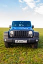 Blue Jeep Wrangler Rubicon Unlimited in wild tulip field near saltwater reservoir lake Manych-Gudilo Royalty Free Stock Photo