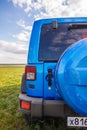 Blue Jeep Wrangler Rubicon Unlimited in wild tulip field near saltwater reservoir lake Manych-Gudilo Royalty Free Stock Photo