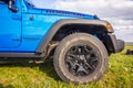 Blue Jeep Wrangler Rubicon Unlimited in wild tulip field near saltwater reservoir lake Manych-Gudilo Royalty Free Stock Photo