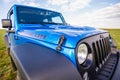 Blue Jeep Wrangler Rubicon Unlimited in wild tulip field near saltwater reservoir lake Manych-Gudilo Royalty Free Stock Photo