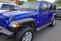 A blue Jeep Wrangler Sport seen on a Jeep dealership lot