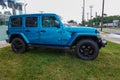 A blue Jeep Wrangler Sport is a very popular vehicle seen on a dealership lot