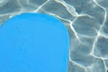 Blue kickboard floating on swimming pool water surface Royalty Free Stock Photo