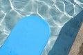 Blue kickboard floating on swimming pool water surface Royalty Free Stock Photo