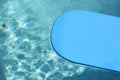 Blue kickboard floating on swimming pool water surface Royalty Free Stock Photo