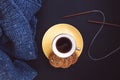 Blue knit sweater, knitting needles, gold cup with coffee and yellow plate with cookies on dark black background Royalty Free Stock Photo