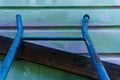 Blue ladder leaning against a weatherboard wall that has been painted with primer, renovating and maintaining an old Kiwi villa.