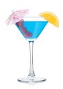 Blue lagoon cocktail in martini glass with orange slice and sweet cherry with umbrella on white Royalty Free Stock Photo