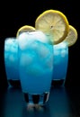 Blue lagoon cocktails with ice cubes, lemon on black Royalty Free Stock Photo