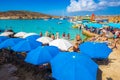 BLUE LAGOON, COMINO, MALTA - October 18, 2016: Tourists crowd to enjoy the clear turquoise water under umbrellas on a sunny day