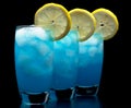 Blue lagoon drinks with slice of lemon isolated on black