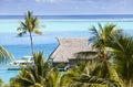 Blue lagoon of the island of Bora Bora, Polynesia. A view from height on palm trees, traditional lodges over water and the sea