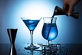 Blue lagoon non-alcoholiccoctail coctail on clean blue background. Bartender's hand Royalty Free Stock Photo