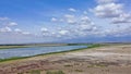 A blue lake on the dry red-brown land of the savannah.