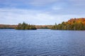 Blue lake with an island in northern Minnesota with trees in autumn color along the shore Royalty Free Stock Photo