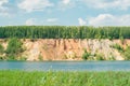 Blue lake with the orange yellow sand hills mountain and forest on top against sky