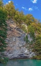 A rock by the blue lake. Abkhazia, near the lake Ritsa. Royalty Free Stock Photo