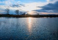 Blue lake surface and radio transmitter tower in illumination of evening sunset Royalty Free Stock Photo