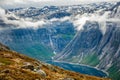 Blue lake surrounded by steep cliffs hiding in clouds, Odda, Hordaland county, Norway Royalty Free Stock Photo