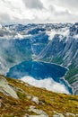 Blue lake surrounded by steep cliffs hiding in clouds, Odda, Hordaland county, Norway Royalty Free Stock Photo