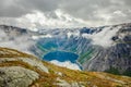 Blue lake surrounded by steep cliffs hiding in clouds, Odda, Hordaland county, Norway Royalty Free Stock Photo