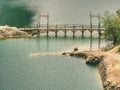 Blue lake with wooden tourist path bridge above cold water Royalty Free Stock Photo