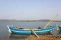 Blue large fishing boat anchored near the shore against the backdrop of the river and green forest Royalty Free Stock Photo