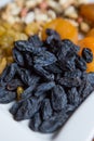 Blue large raisins. Large white plate with nuts raisins and dried fruits