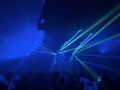 Blue laser light criss crossing a dark room over a crowd. Royalty Free Stock Photo