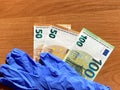 Blue latex gloves and 50 and 100 euro bills. For the cashier or seller, sale. The bottom of the picture Royalty Free Stock Photo
