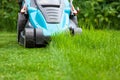 Blue lawn mower on green grass cut the grass