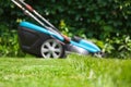 Blue lawn mower on green grass