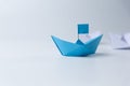 Blue leader paper ship leading hind white on white background