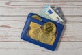 Blue leather wallet with Bitcoin coins, Euro bills and bank card. Wooden background. Close-up. Top view. Royalty Free Stock Photo