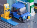 A blue Lego electric car charging at a charging station