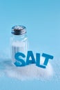 Blue letters spelling the word salt and salt shaker