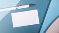 On a blue, light blue and pink background, there is a white blank card with a place to insert text on a paper clip and a white pen Royalty Free Stock Photo