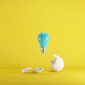 Blue light bulb floating from white eggshell on yellow background. Royalty Free Stock Photo