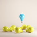 Blue light bulb floating among yellow light bulbs on background. Royalty Free Stock Photo