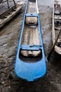 Blue and light colored fishing canoe resting on the sands of the river Royalty Free Stock Photo