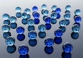 Blue and light blue glass marbles scattered on a reflective surface. Each marble is smooth, Royalty Free Stock Photo