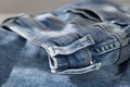 a blue light jeans on a grey background. Close up. Sunlight