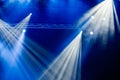 Blue light rays from the spotlight through the smoke at the theater or concert hall. Lighting equipment for a performance or show Royalty Free Stock Photo