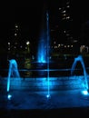 A blue lighted fountain at night