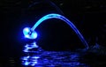 Blue-lighted water gush at night
