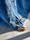 Blue linen fabric with grommets and rope on a textured surface. Royalty Free Stock Photo