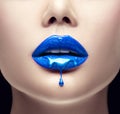 Blue lipstick dripping. Lipgloss dripping from lips, Blue liquid drops on beautiful model girl`s mouth, creative makeup