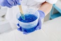 Blue liquid epilation paste and a spatula in the hands of a beautician. Close-up. Shugaring Royalty Free Stock Photo